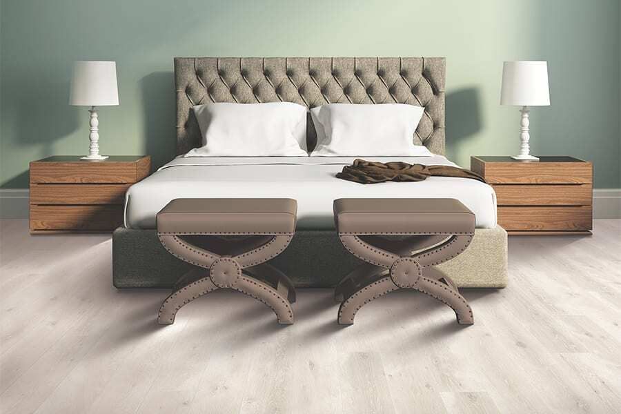 a bedroom with a bed , two nightstands , two benches and two lamps