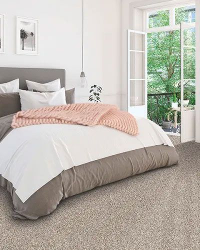 a bedroom with a bed , a window and a carpet .