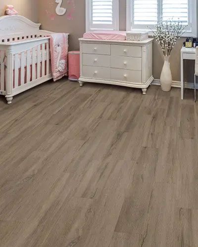 a nursery with a crib , dresser , and desk .