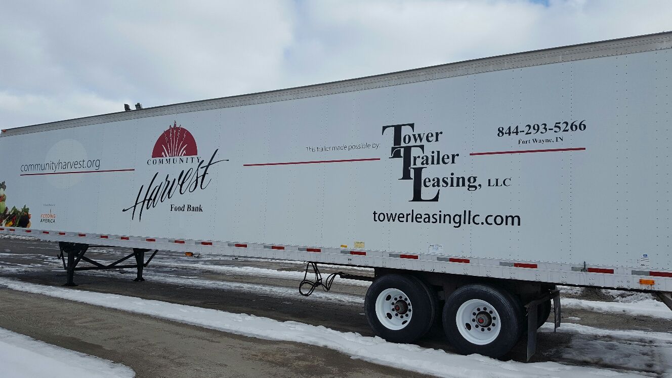 A white trailer is parked on the side of the road in the snow.