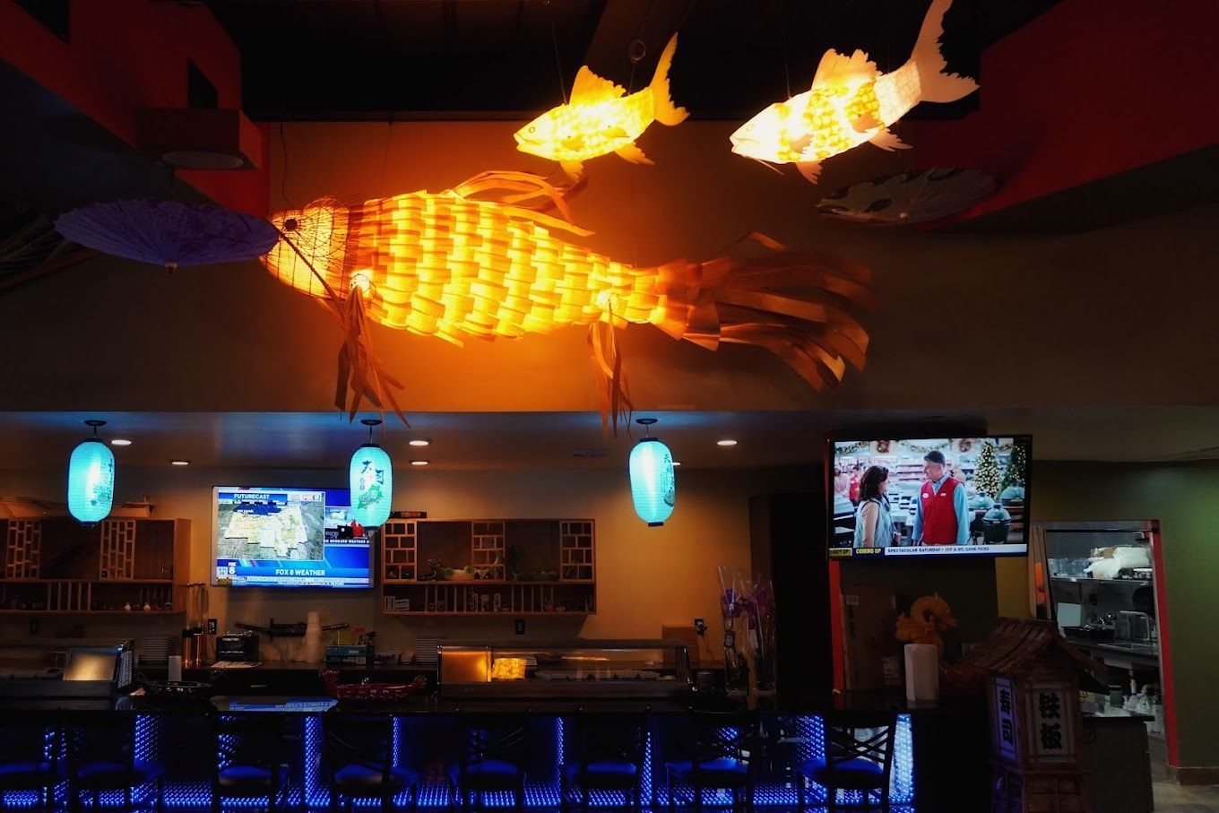 A restaurant with a large fish hanging from the ceiling.