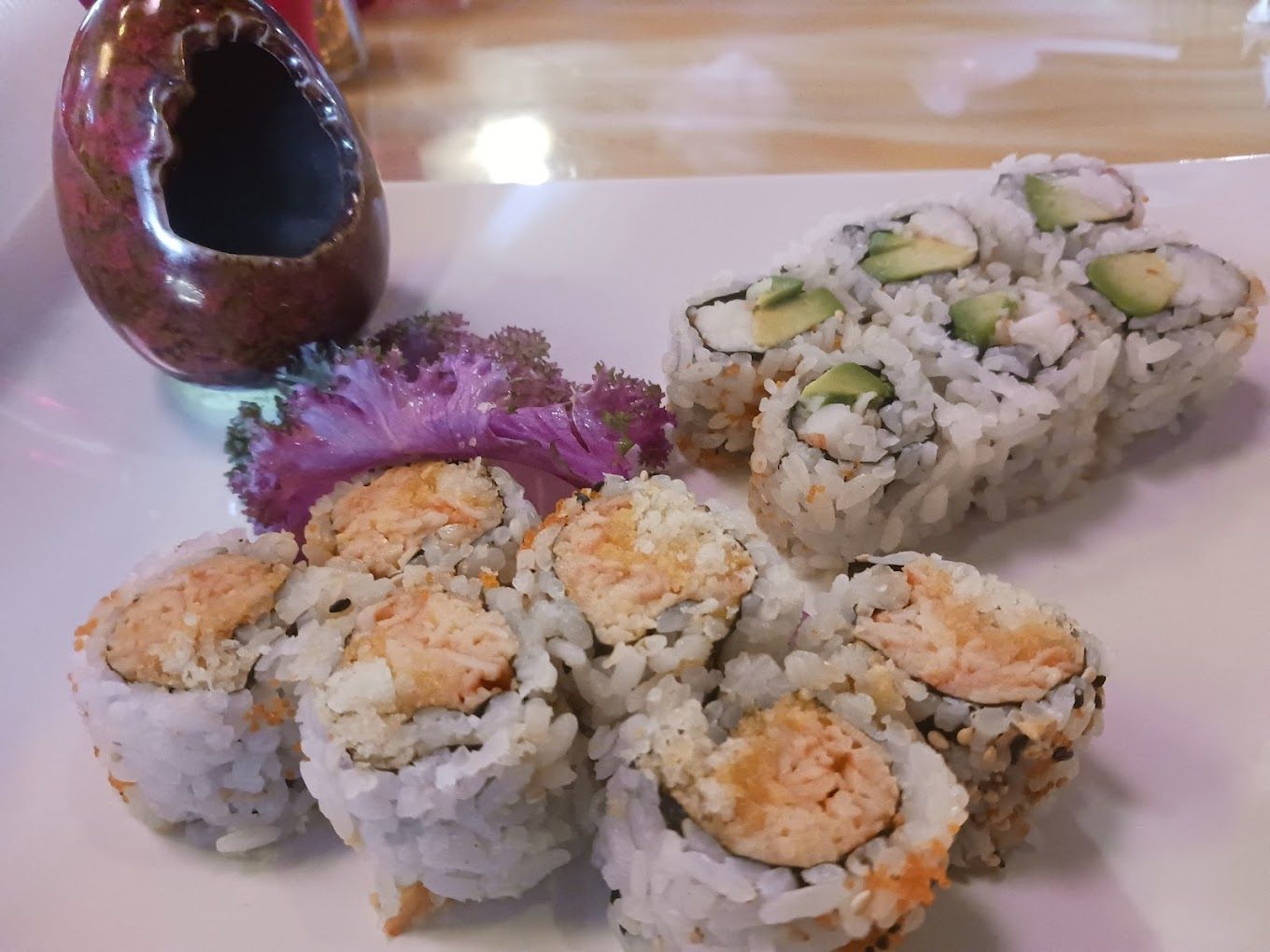 A white plate topped with a variety of sushi rolls