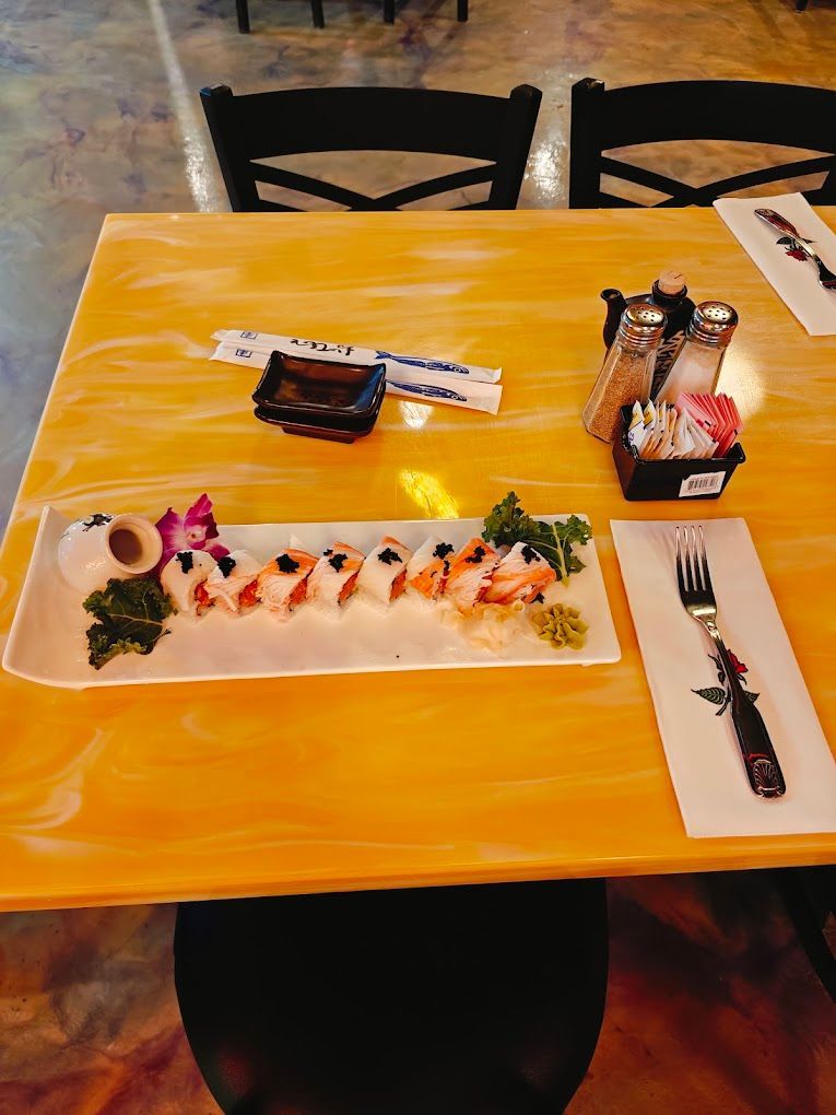 A yellow table with a plate of sushi on it.