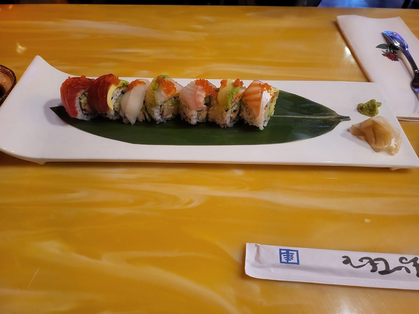 A plate of sushi on a leaf on a table