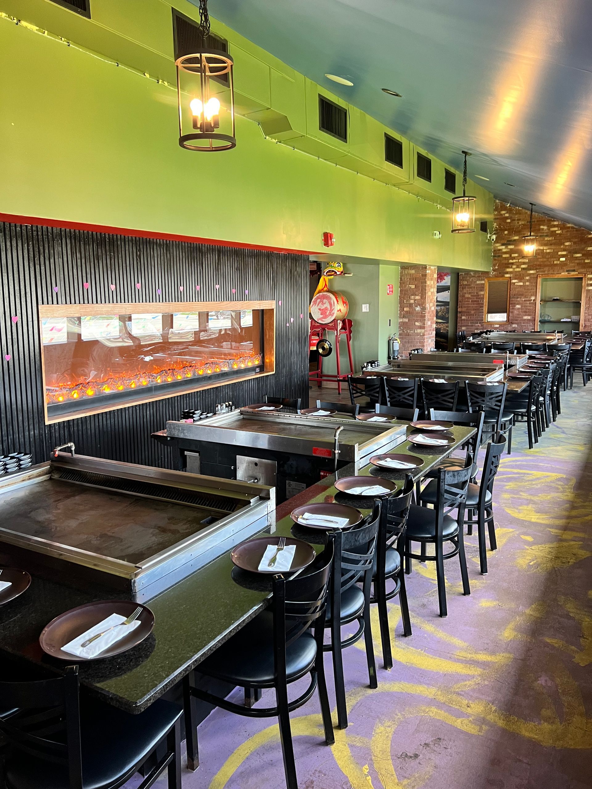 A long dining room with tables and chairs in a restaurant.