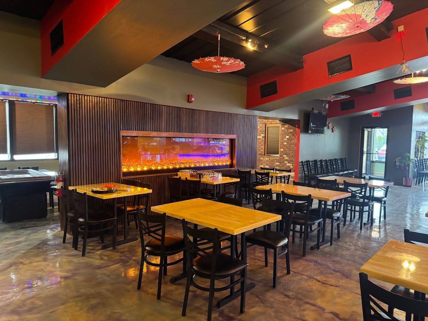 A restaurant filled with tables and chairs and a fireplace.