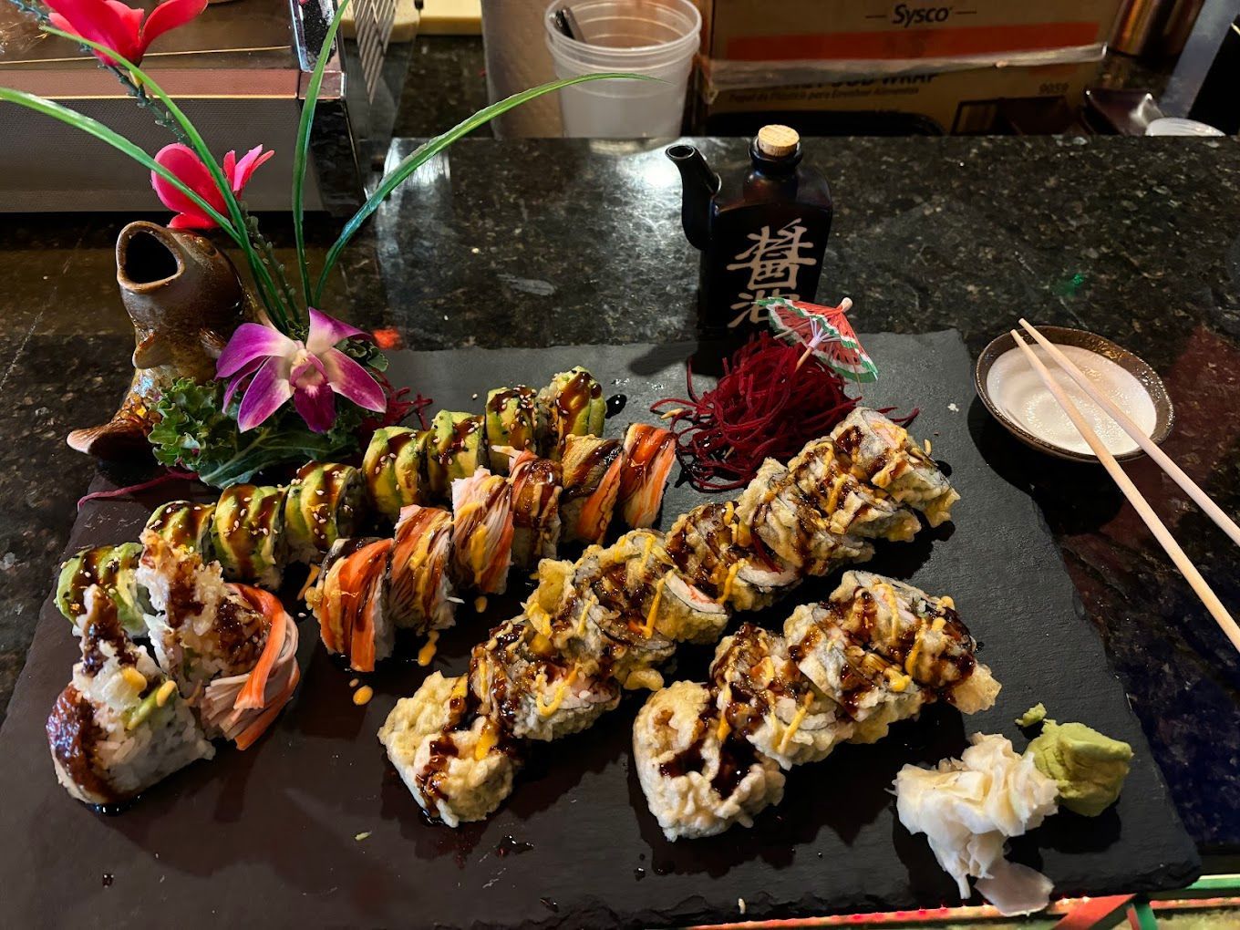 A table topped with a variety of sushi rolls and chopsticks.
