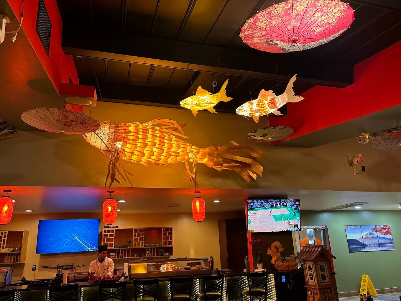 A restaurant with a large fish hanging from the ceiling.