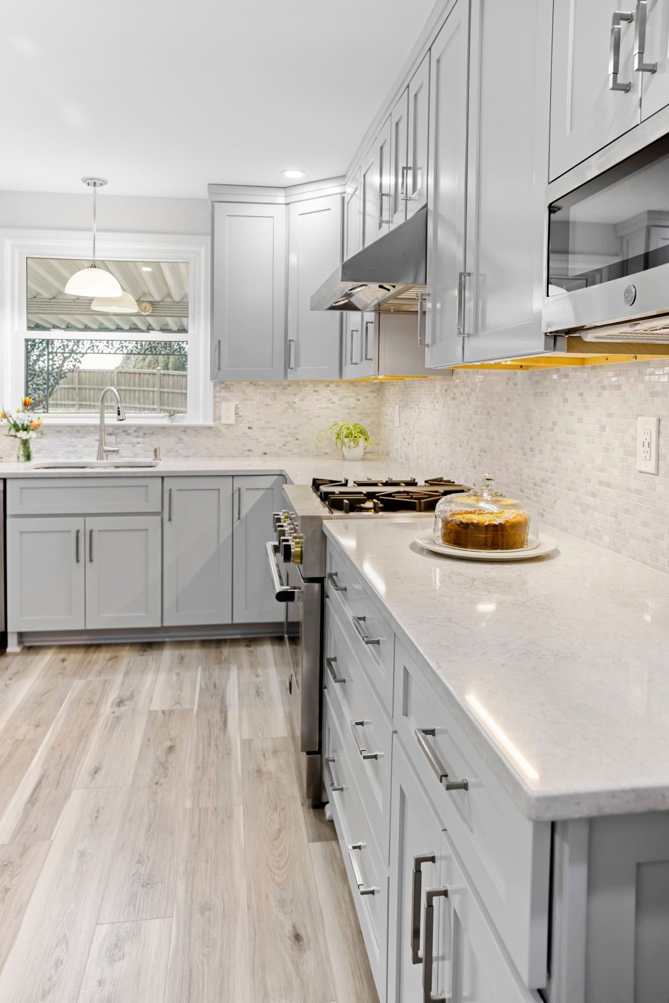 Light gray kitchen with cabinets, countertops, and stainless steel appliances.