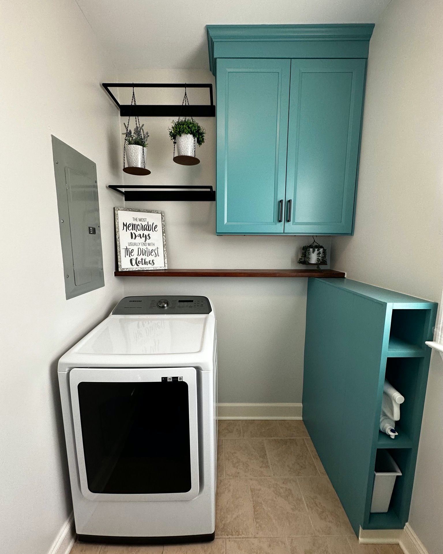Laundry room with turquoise cabinets, shelves, and a white washer.