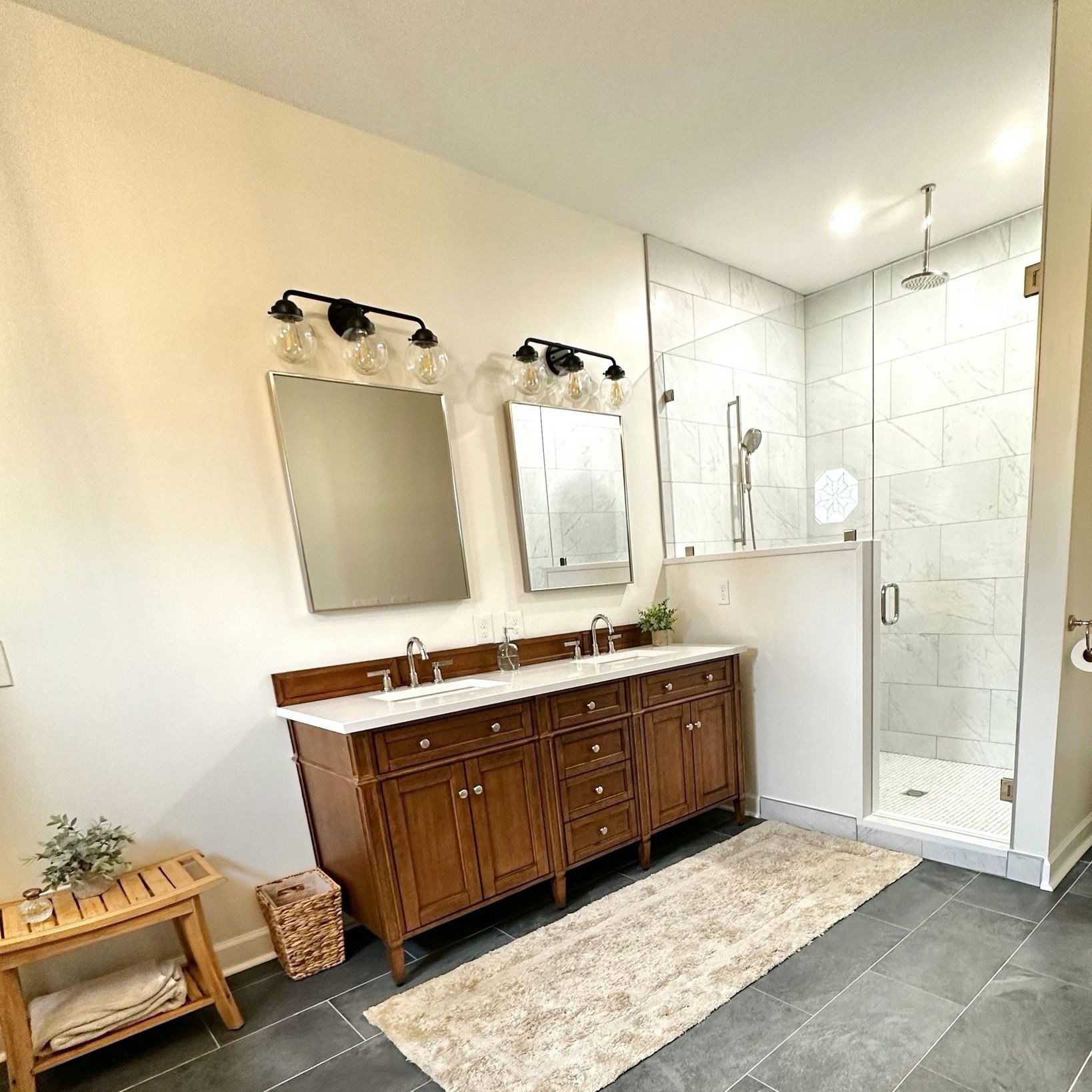 Bathroom with a double vanity, large mirrors, and a walk-in shower.