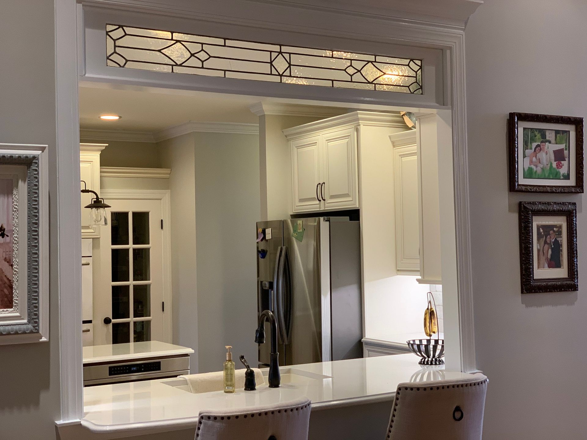 A kitchen pass-through with a countertop, cabinetry, and a stained glass accent.