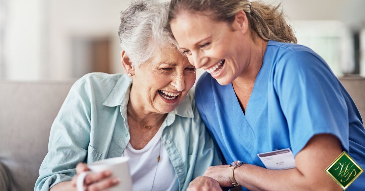 elderly woman laughing with her caregiver - Whispering Pines senior care