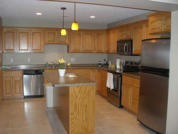 Modern kitchen with wood cabinets, stainless steel appliances, island, and pendant lights