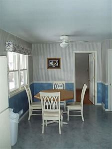 Bright dining room with a table, four chairs, windows, and blue-and-white walls