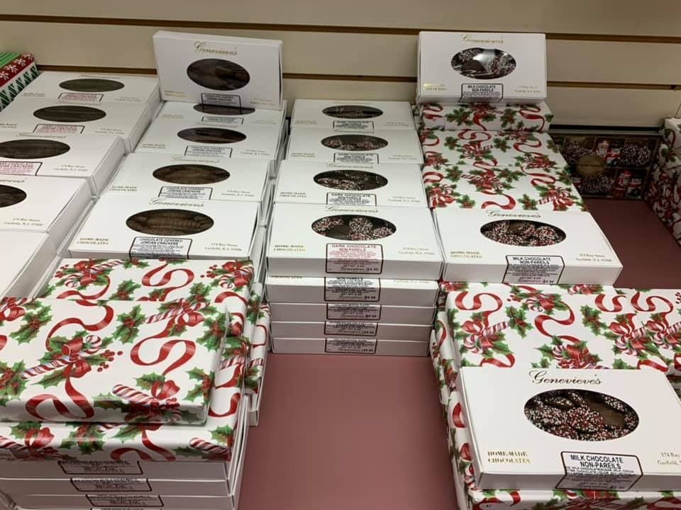 Boxes of chocolate candies on a store shelf, some with Christmas-themed wrapping.