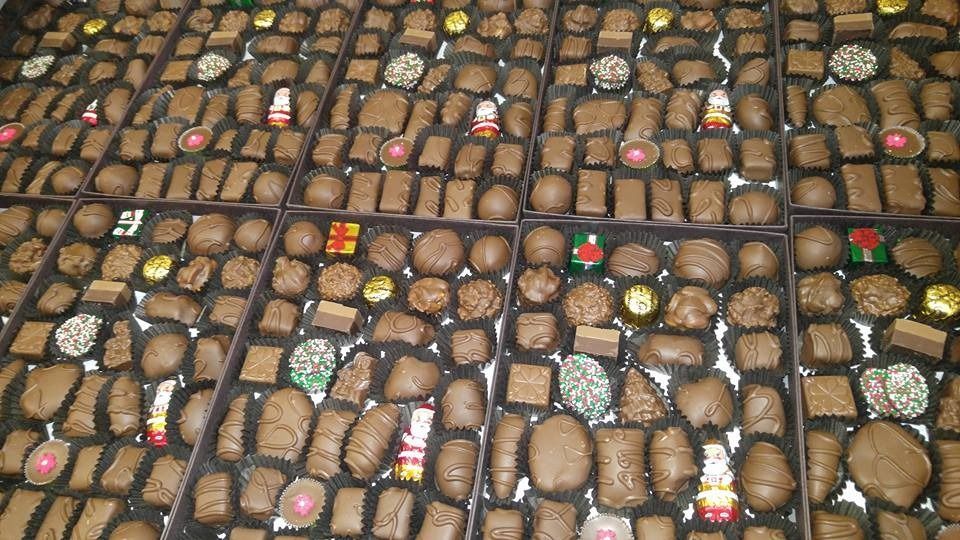 Assorted chocolates arranged in trays, various shapes and sizes, dark and light brown candies.