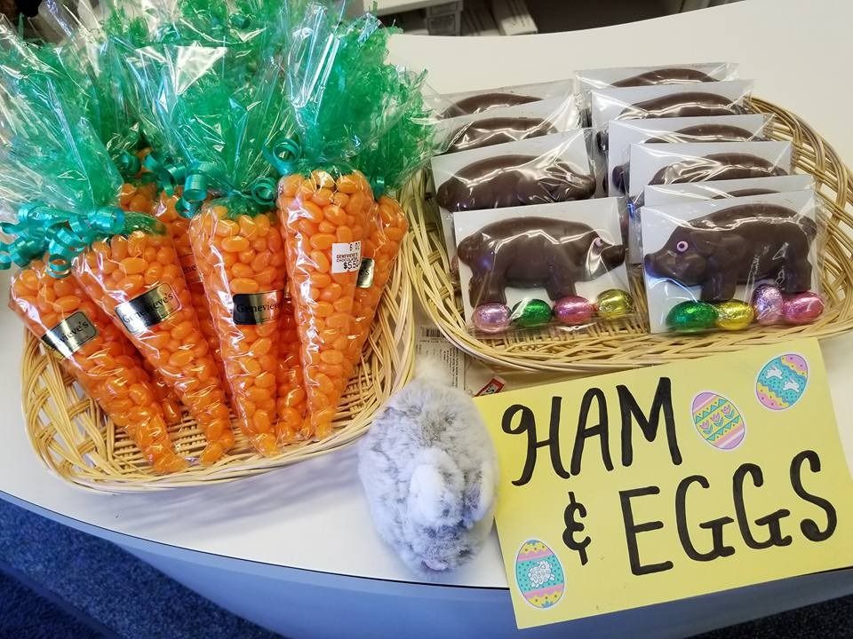 Easter candy display with carrot-shaped bags, chocolate bears, foil-wrapped eggs, and a sign that says 