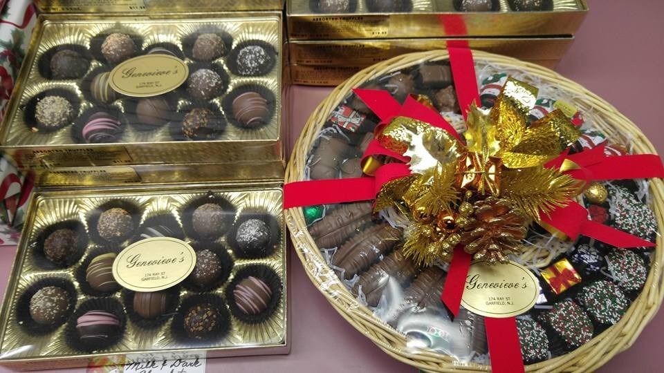 Chocolate truffles in boxes and a basket, tied with a red ribbon and gold bow.