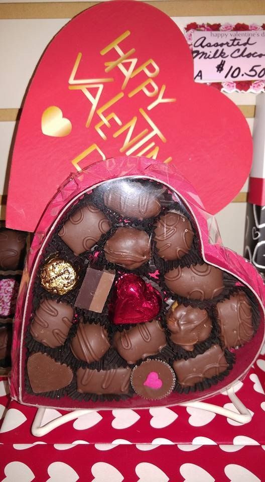 Heart-shaped box of chocolates on a red and white heart-patterned cloth, with