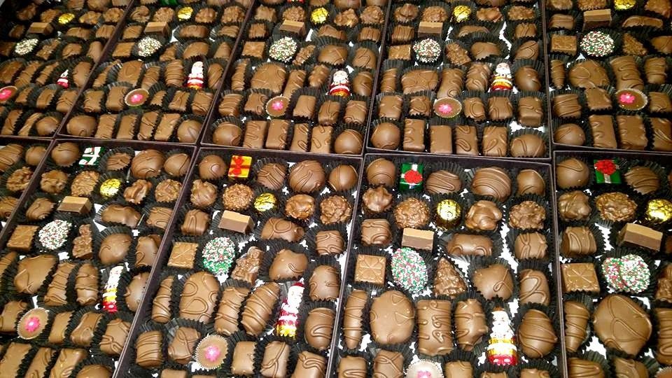 Boxes overflowing with assorted chocolate candies.