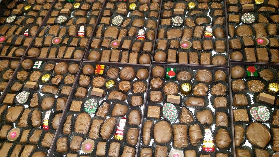 Assortment of chocolate candies in various shapes and sizes, displayed in open boxes.