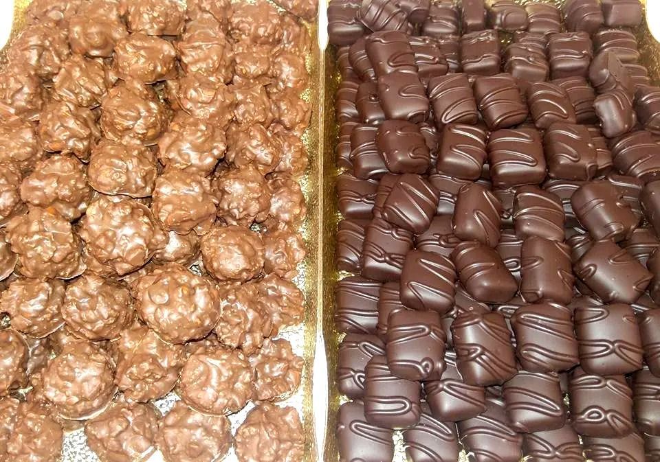 Two trays of chocolate candies: textured brown balls and dark, drizzled squares.
