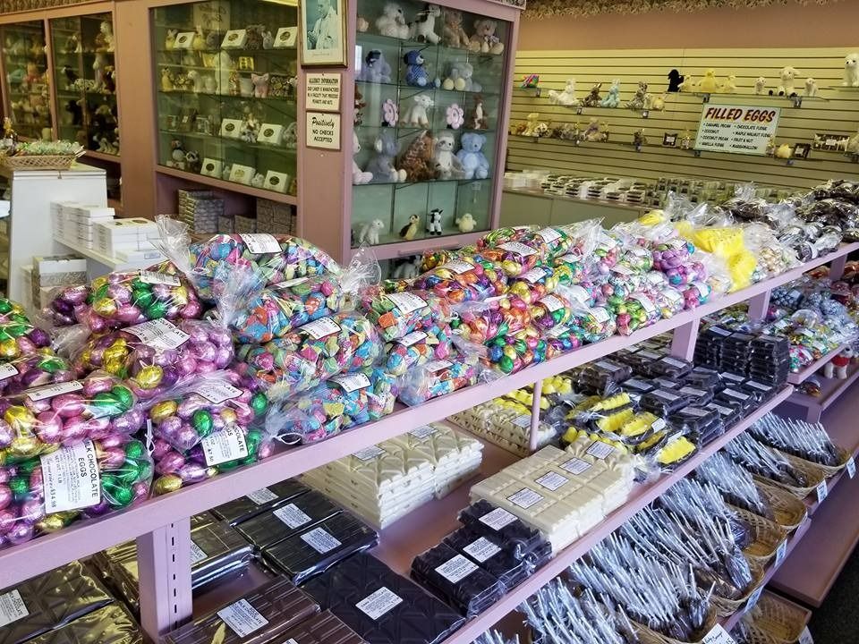 Candy store interior with shelves overflowing with colorful wrapped candies and chocolates.