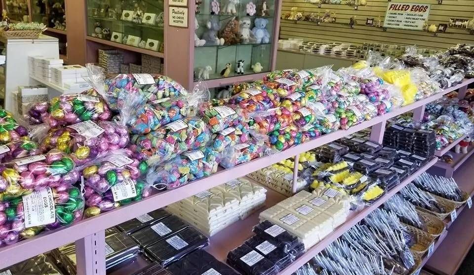Shelves filled with various packaged candies, chocolates, and treats in a retail store setting.