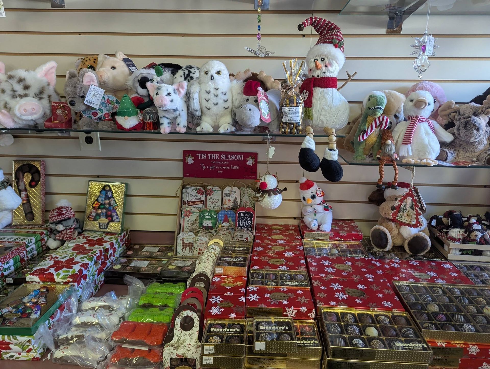 Shelves with stuffed animals and chocolate boxes decorated for Christmas.