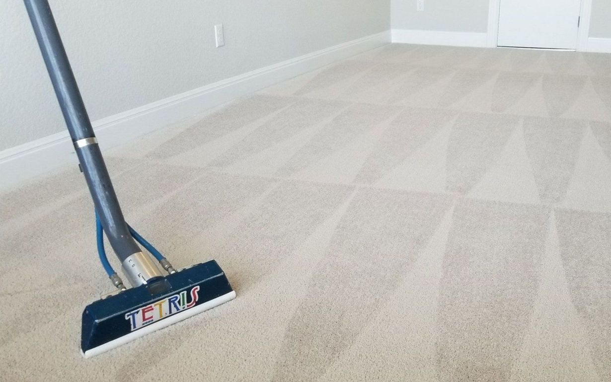 Carpet cleaner on a beige carpet in an empty room