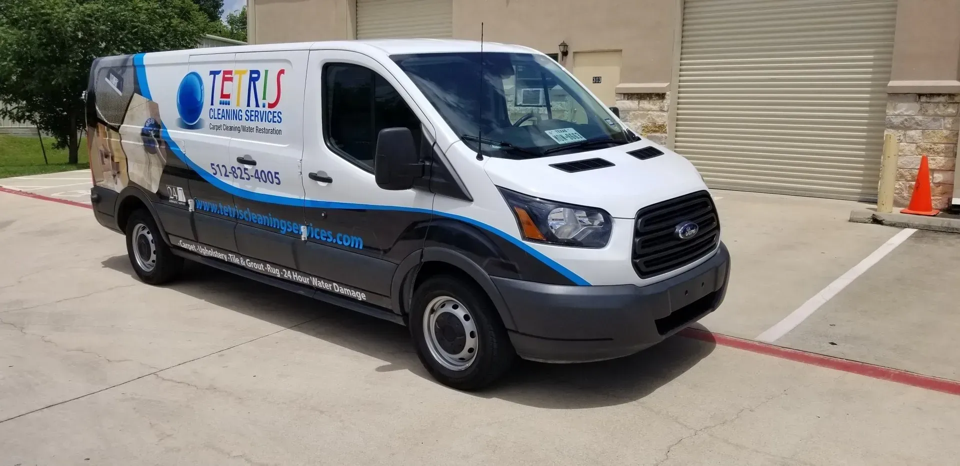 White service van with blue and black graphics parked outdoors on a concrete lot