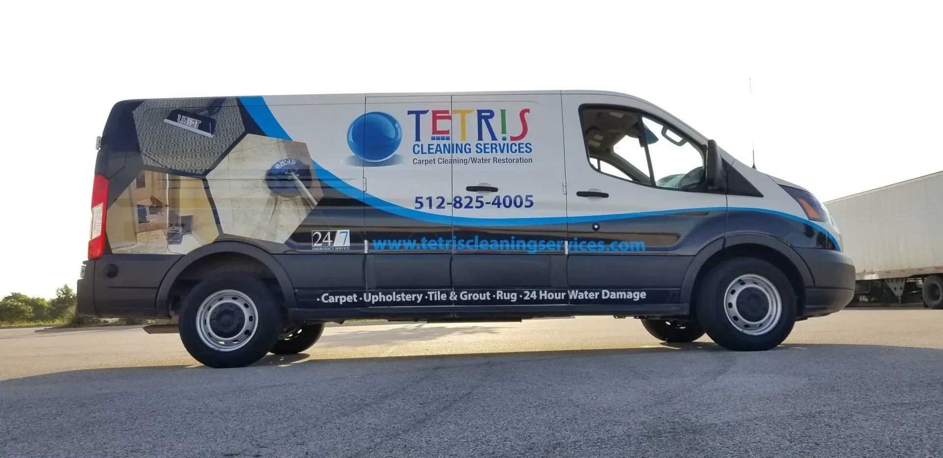 Side view of a white and blue TERIS service van parked on a road.