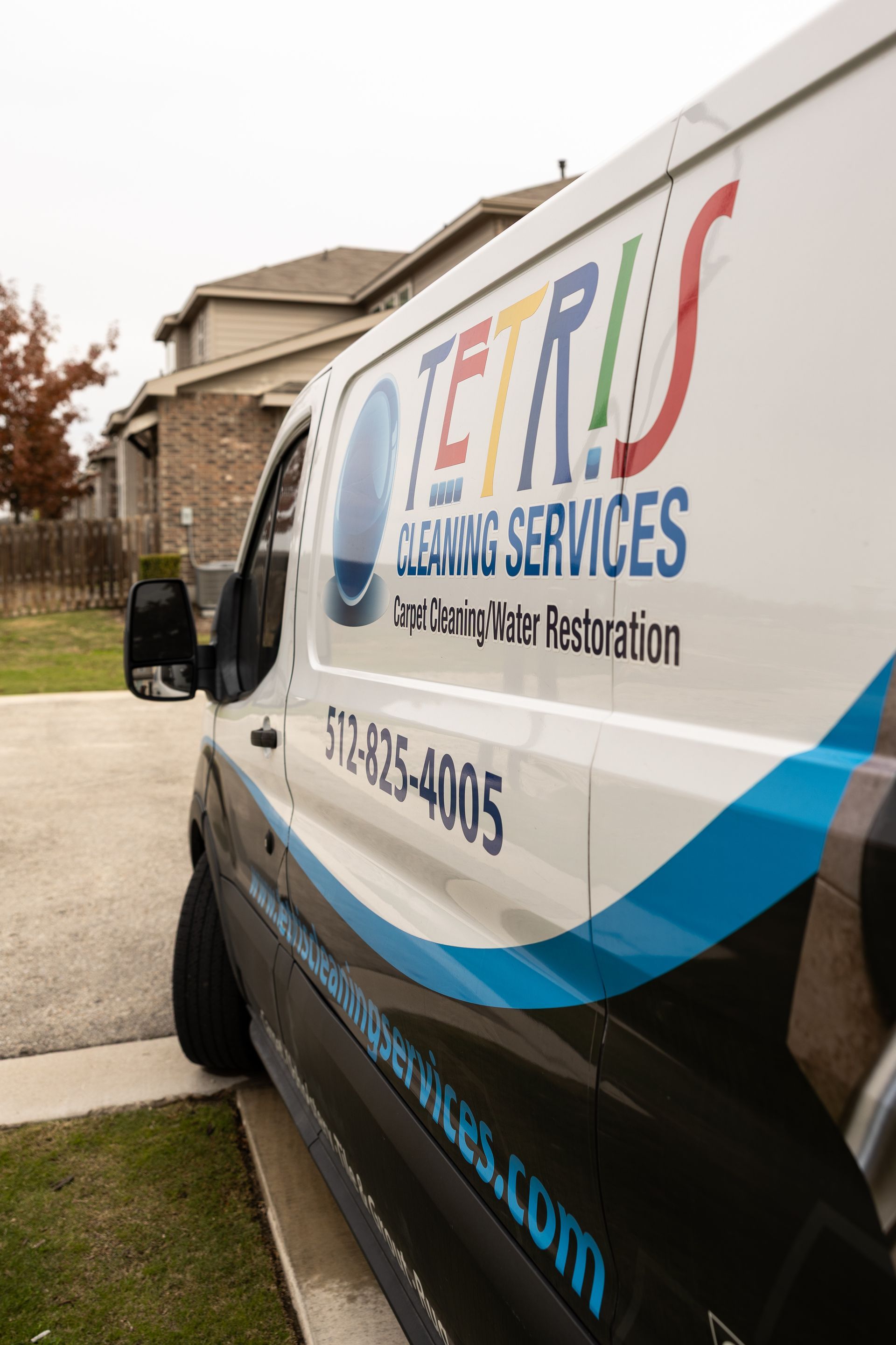 White service van with “TERRY’S Cleaning Services” logo parked beside a house and lawn.