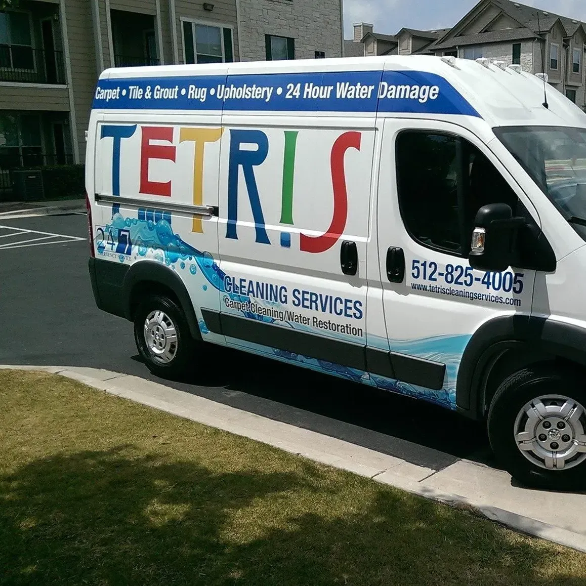 White TETRIS leak services van parked on a street, blue/red lettering and water damage repair ad.