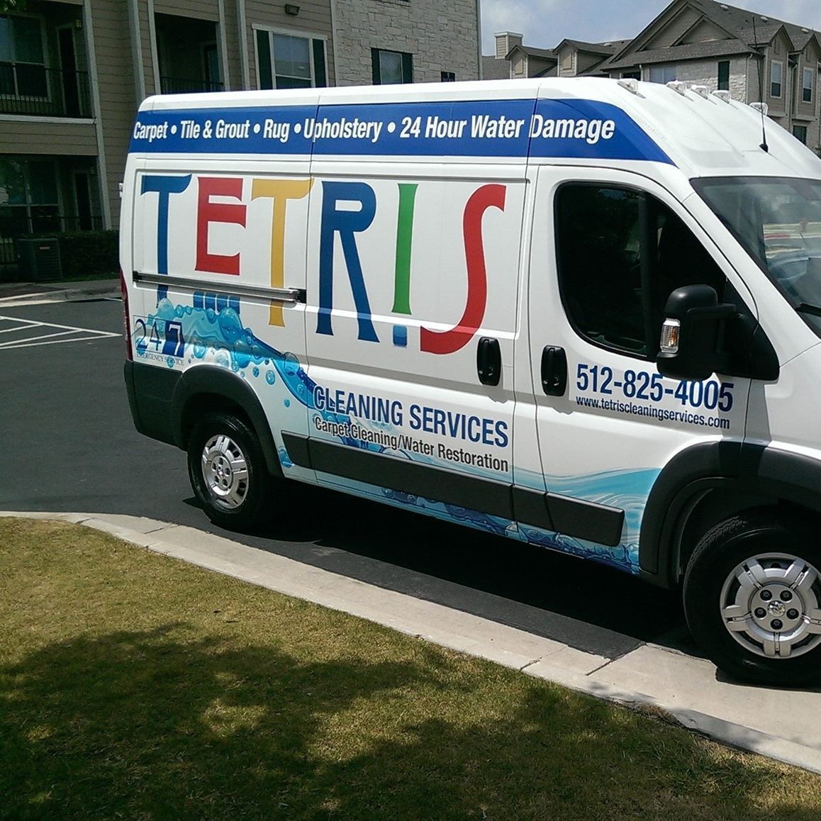 Tetris Cleaning Services van parked curbside, with large colorful logo and water damage restoration text.