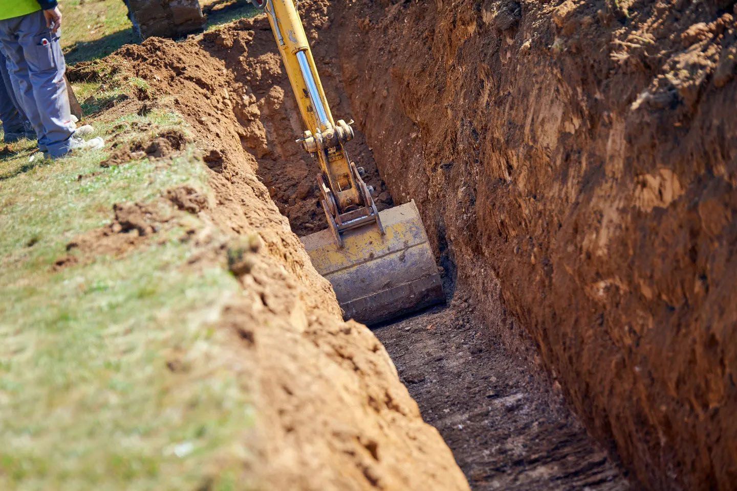 a yellow excavator is digging a hole in the ground