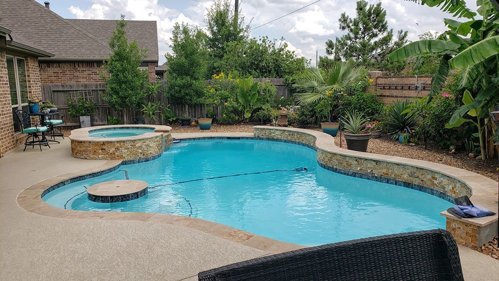 There is a large swimming pool in the backyard of a house.