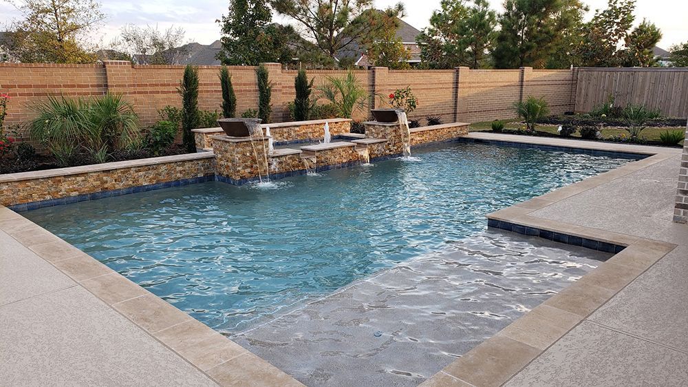 A large swimming pool with a waterfall in the middle of it