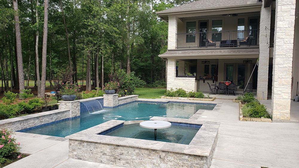 There is a large swimming pool in the backyard of a house.