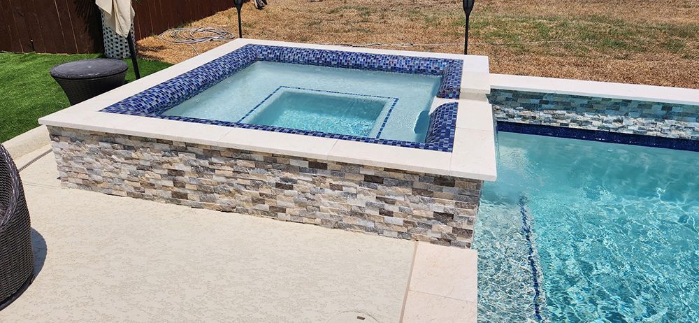 A swimming pool with a hot tub in the middle of it.