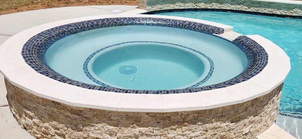 A hot tub is sitting next to a swimming pool.