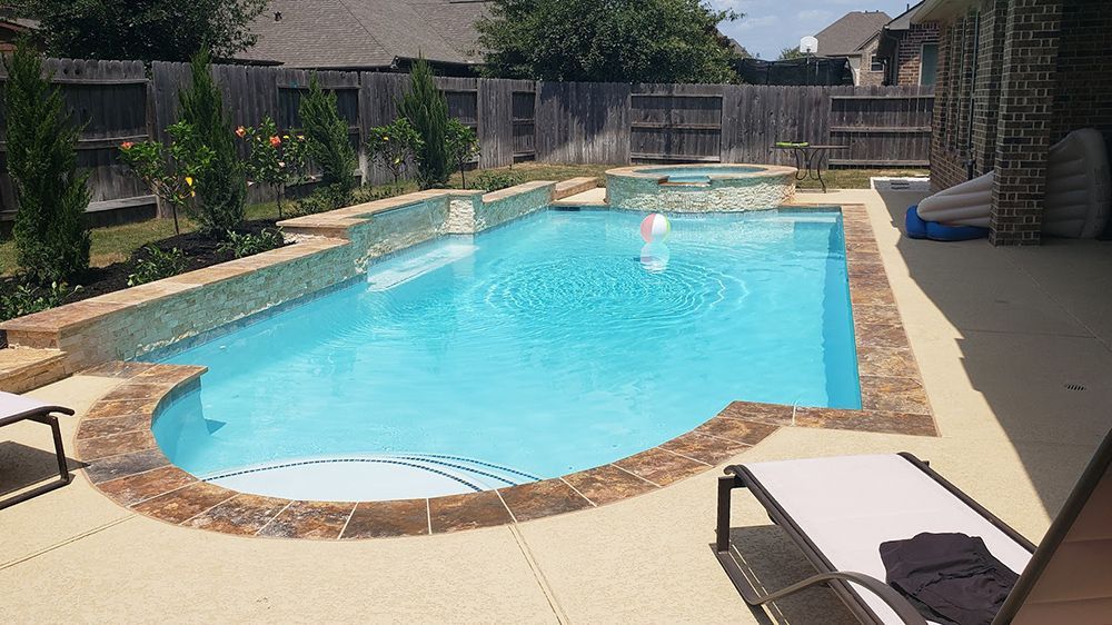 There is a large swimming pool in the backyard of a house.