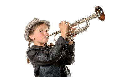 A pretty little girl with a black jacket and hat plays the trumpet