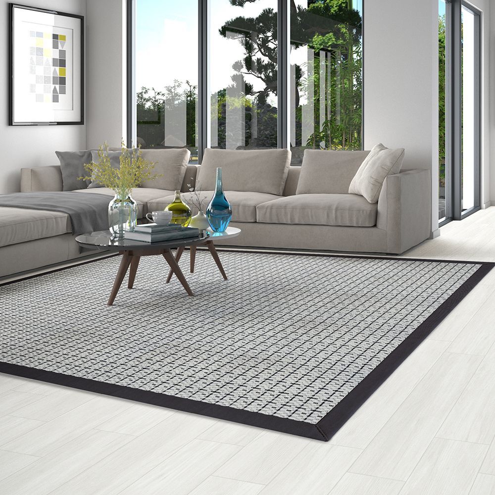 A living room with a couch , coffee table , and rug.