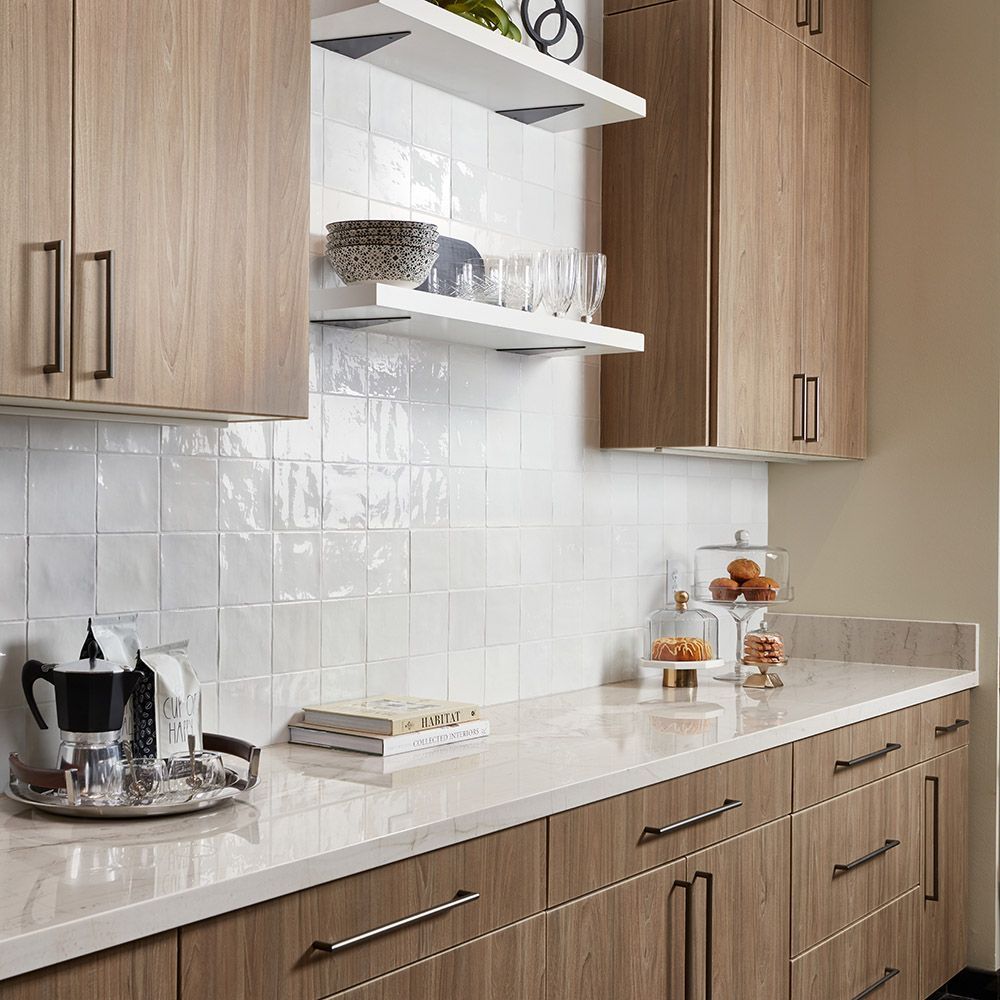 A kitchen with wooden cabinets and white counter tops