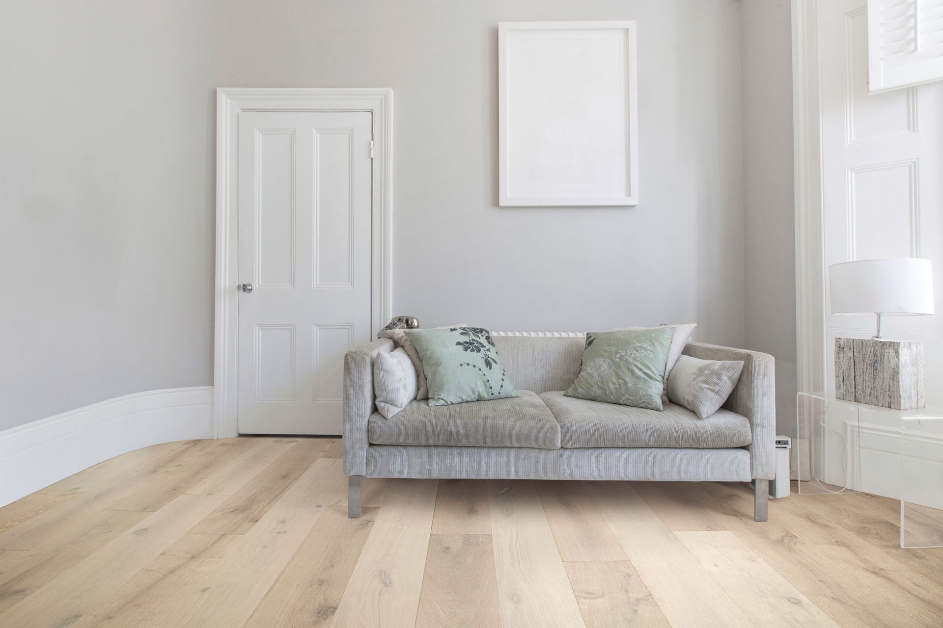 A living room with a couch and a picture on the wall.