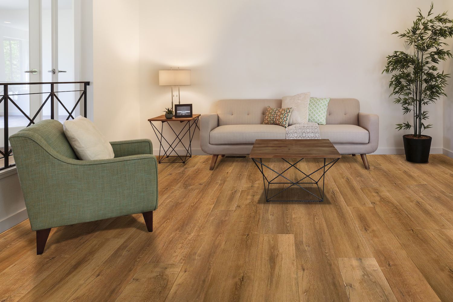 A living room with a couch , chair , coffee table and plant.