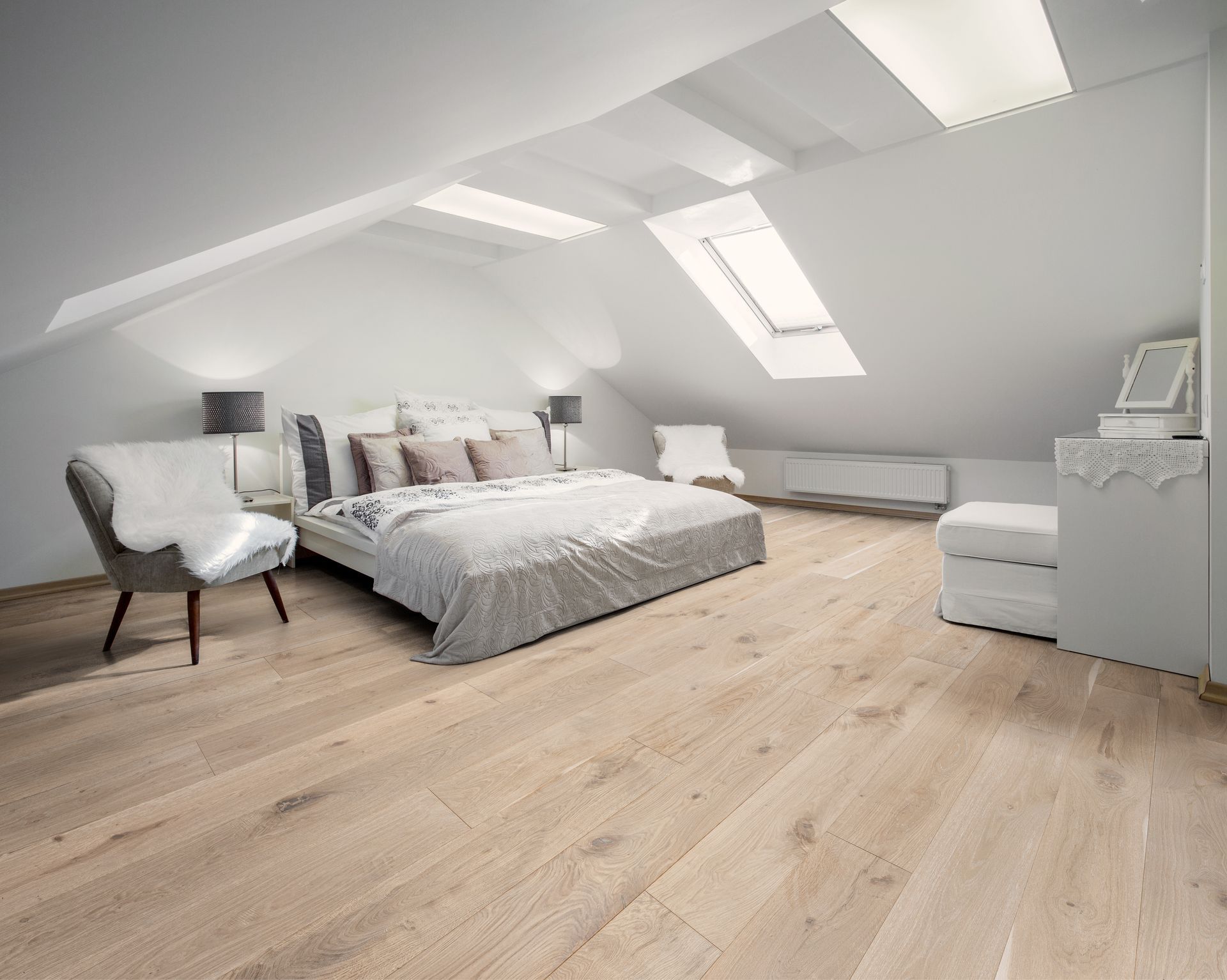 A bedroom with hardwood floors and a large bed.