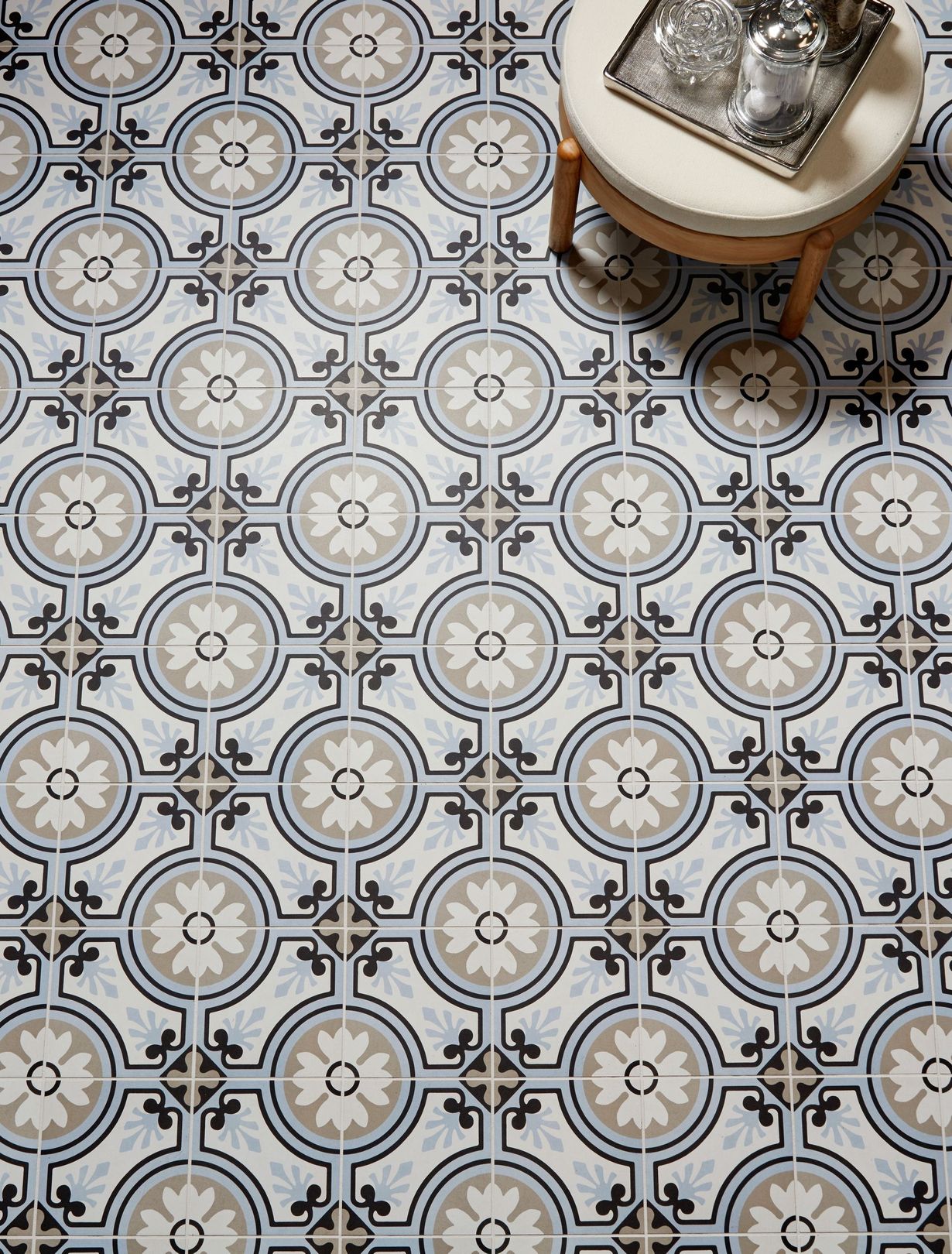 A stool is sitting on a tiled floor next to a table.